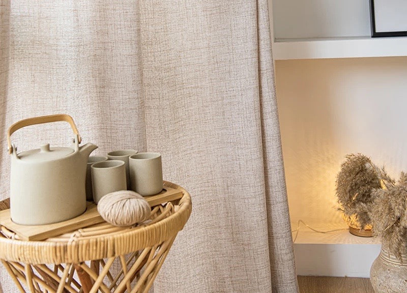 Oatmeal voile curtain beside rattan side table